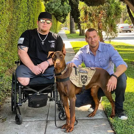 A veteran in a wheelchair with his service dog