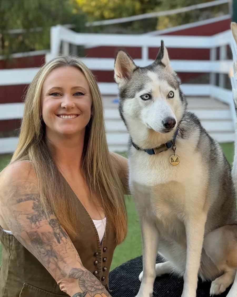 AJ at the ranch with two huskies